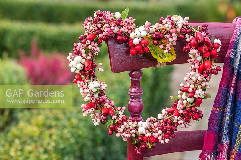 Autumnal berry wreath hanging on dark red chair