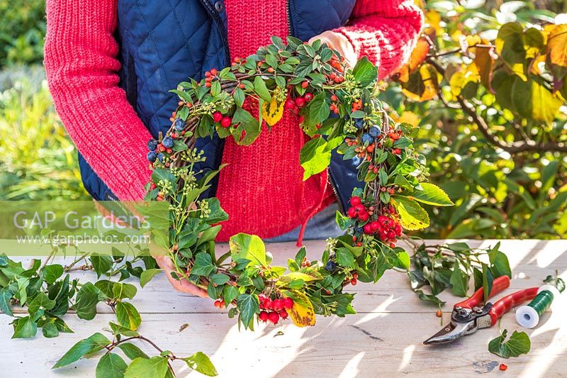 Woman holding the finished Autumnal wreath