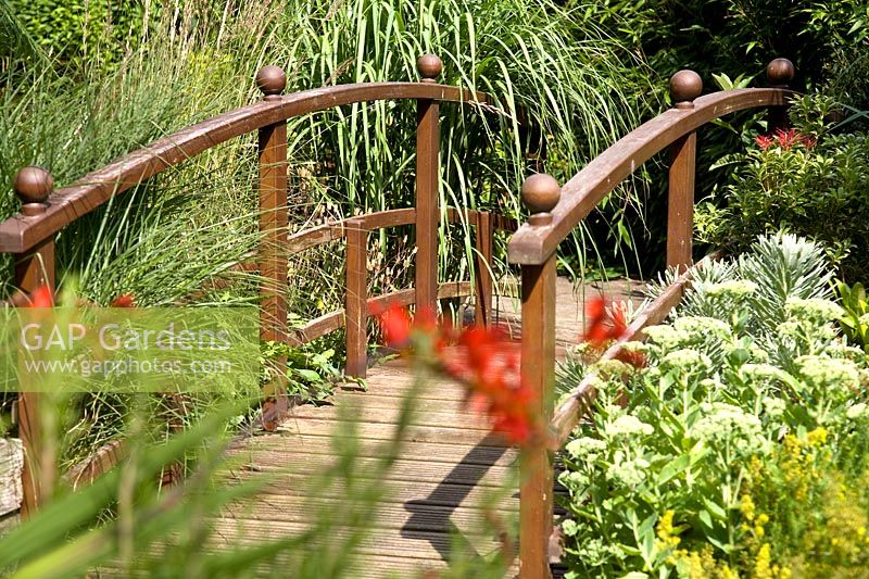 Wooden bridge surrounded by mixed planting