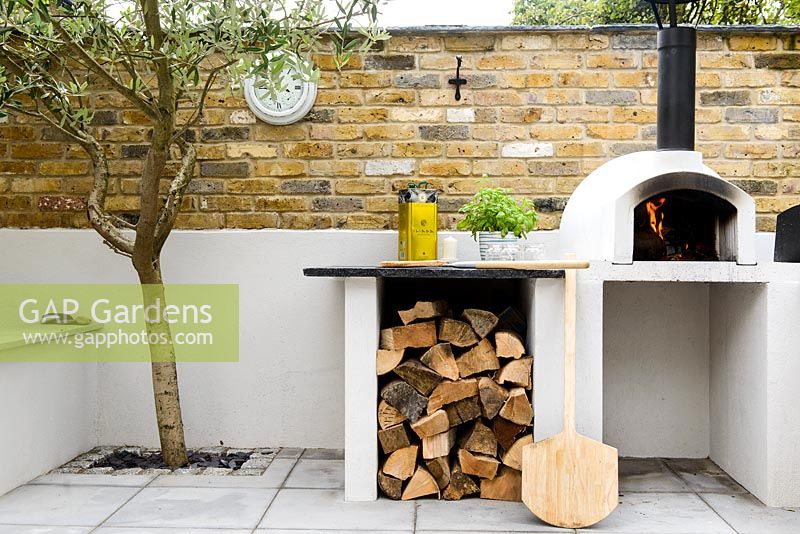 Pizza oven with built in worksurface and wood storage