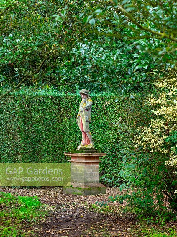 Statue on brick plinth in woodland area