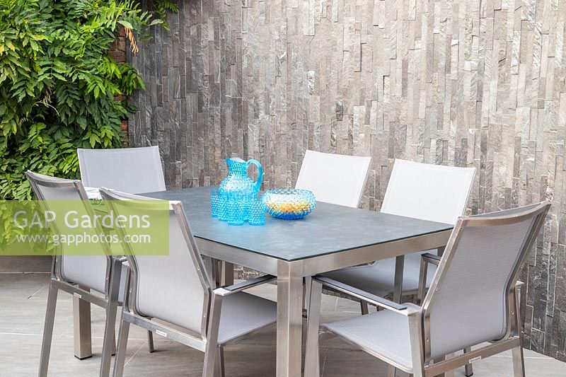Modern dining furniture backed by slate covered wall