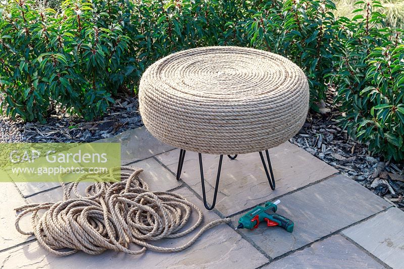 Completed tyre table covered in jute rope in circular pattern on patio