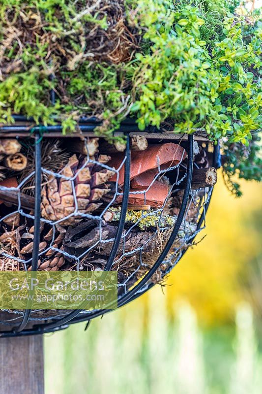 Detail of finished globe insect hotel mounted on a post. 