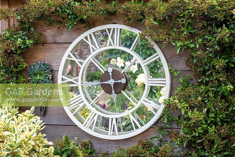 Roses are reflected in a home made mirror clock.
