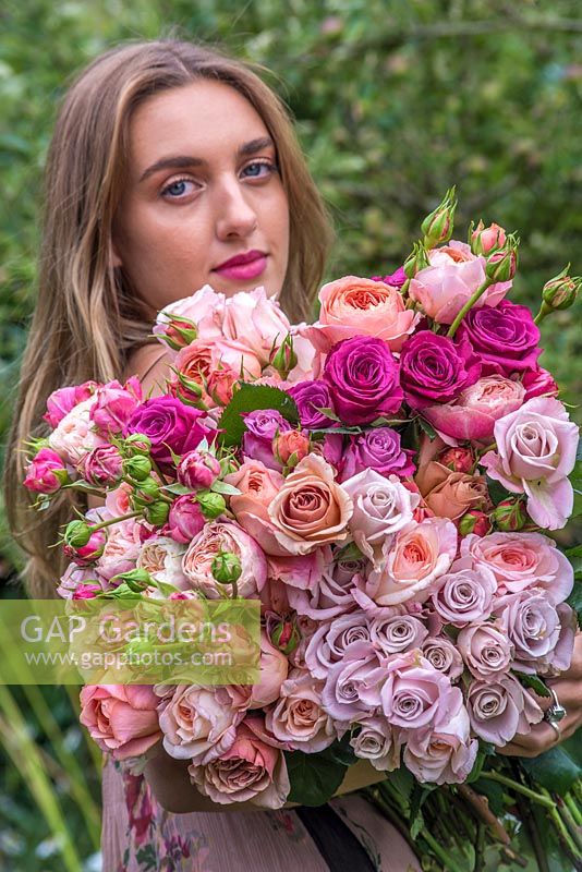 Young woman holding large bunch of roses