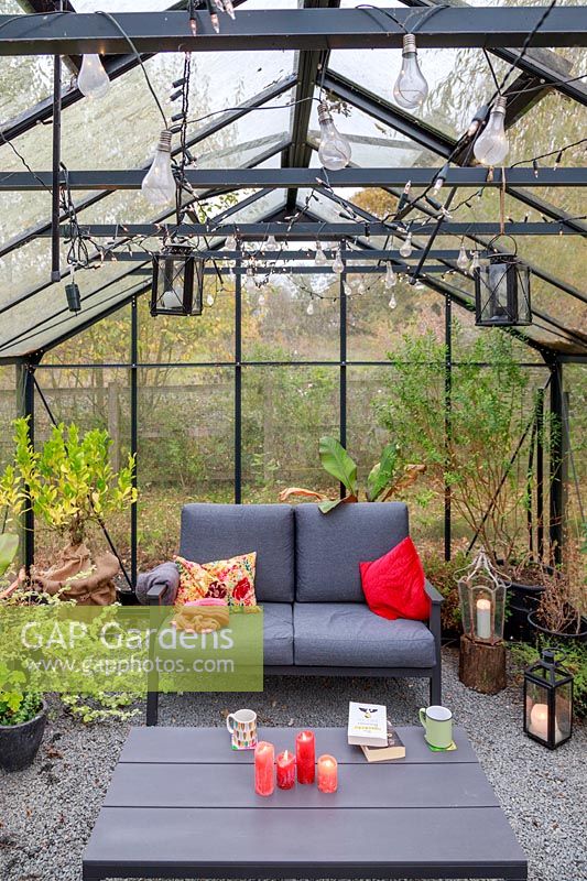 Large greenhouse with lounge furniture, cushions and lighting