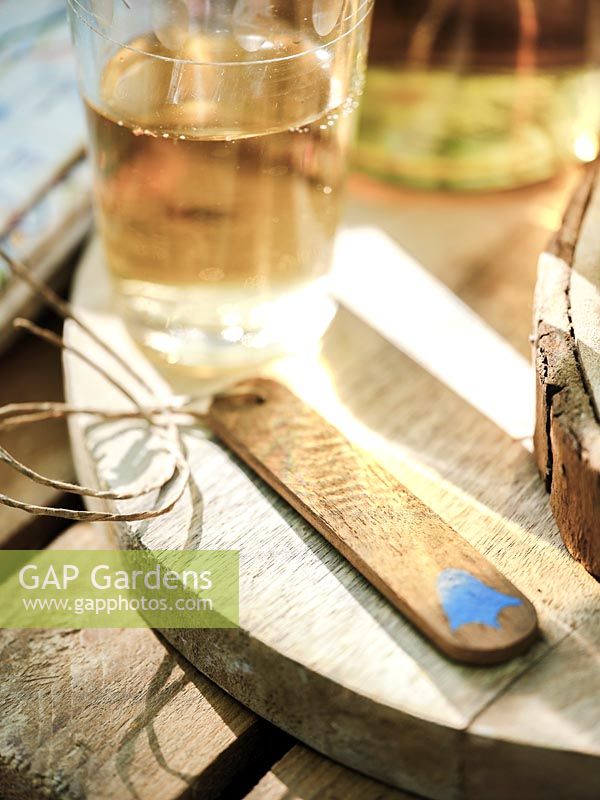 Wooden bottle tag  with painted bluebell, glass bottles and glasses. 