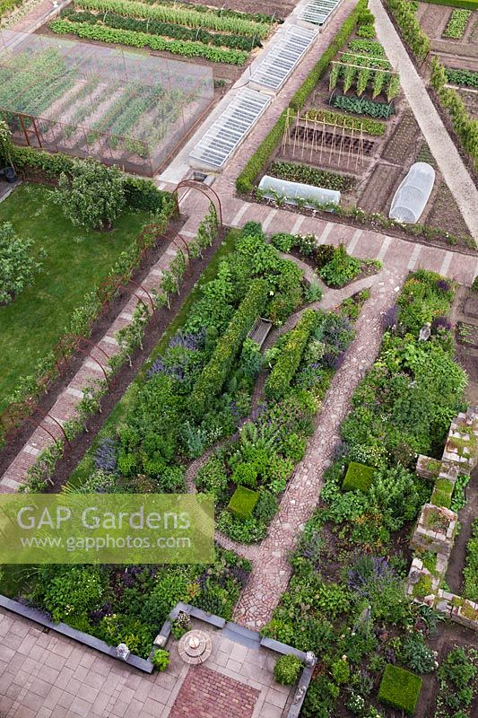 Aerial view of garden with flowerbeds and vegetable plot linked by brick and stone pathways - Holland