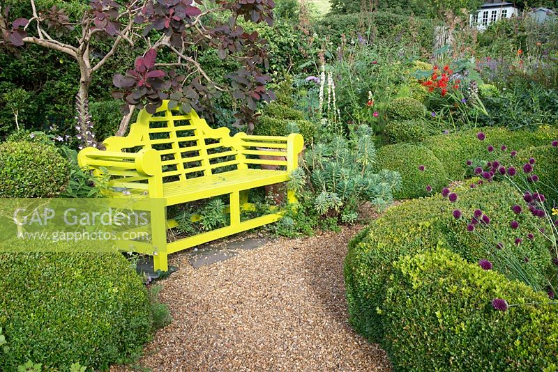 Lutyens style bench in Buxus parterre garden. 