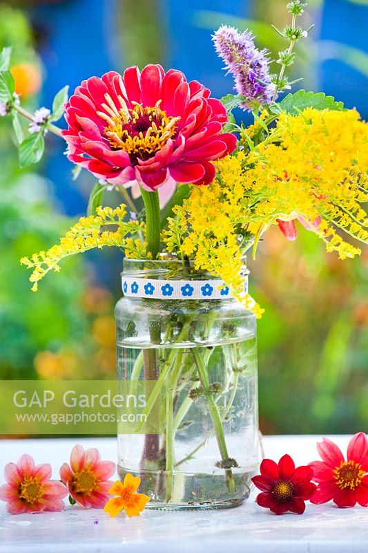 Flower arrangement of Zinnia and Solidago in a glass jar