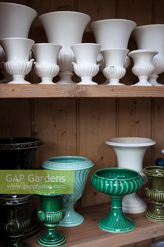 collection of white and green vases and urns in the flower arranging studio. 
