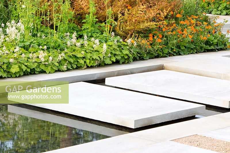 Large sawn Yorkstone floating stepping stone slabs over a water feature. The Sunken Retreat. RHS Malvern Spring Festival, 2016. Design: Ann Walker for Graduate Gardeners