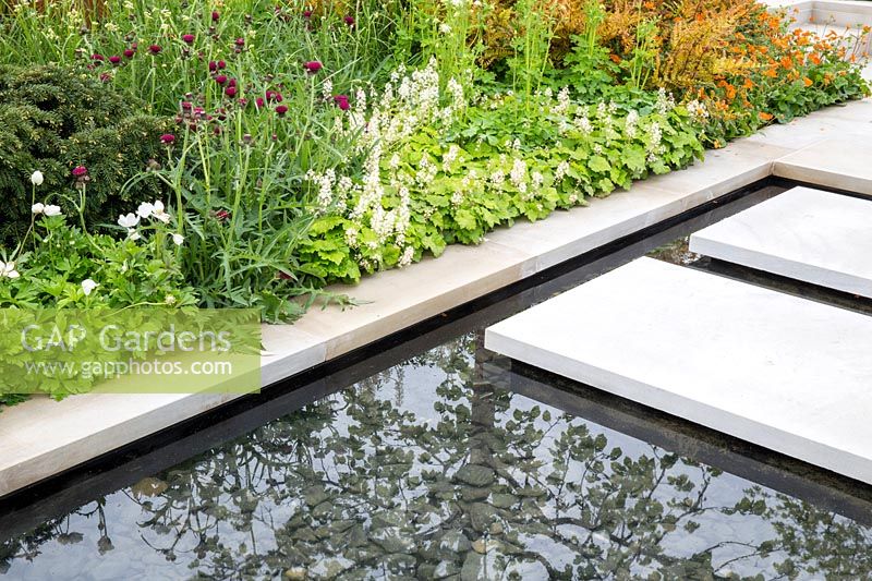 Large sawn Yorkstone floating stepping stone slabs over a water feature. The Sunken Retreat. RHS Malvern Spring Festival, 2016. Design: Ann Walker for Graduate Gardeners
