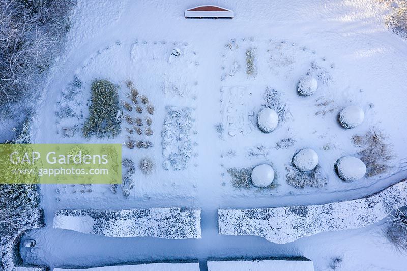 Aerial view of formal country garden covered in snow - Veddw House Garden