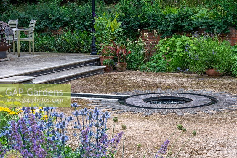 A Carlton Landscapes built rill leading into the double circles in a sun style design created from laying slated on their sides.