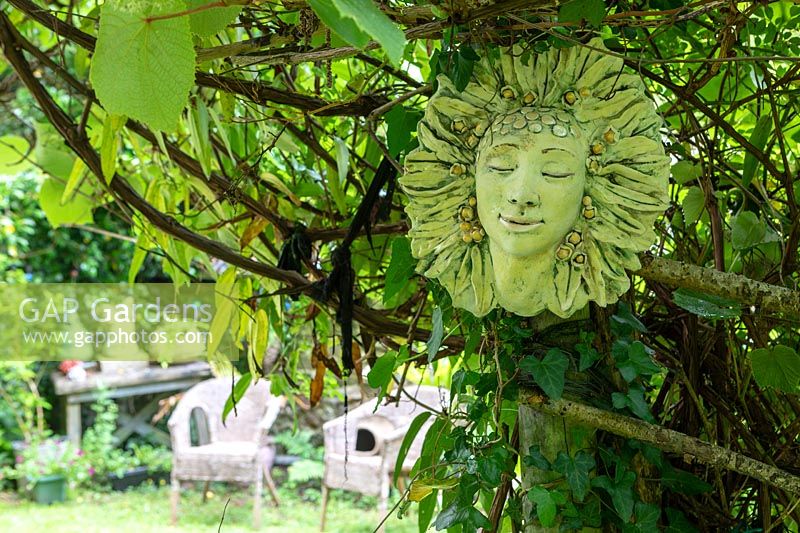Ceramic face hanging in tree
