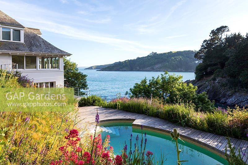 Informal garden with a mix of perennials and annuals, view of pool, house and sea