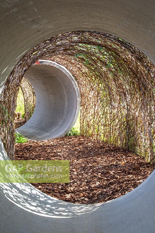 Tunnel made from concrete piping and weaved willow. The Thames Water Flourishing Future Garden - Hampton Court Flower Festival 2019