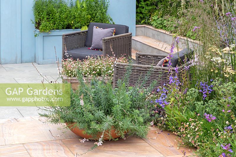 Paved seating area with Linaria purpurea 'Canon Went' in a shallow container. Viking Cruises World of Discovery Garden, RHS Hampton Court Palace Flower Show, 2017. 