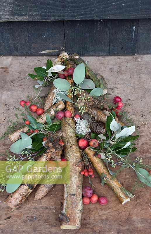 Rustic Christmas tree arrangement with birch sticks, berries, Eucalyptus and pine foliage plus pinecones. Styling: Marieke Nolsen