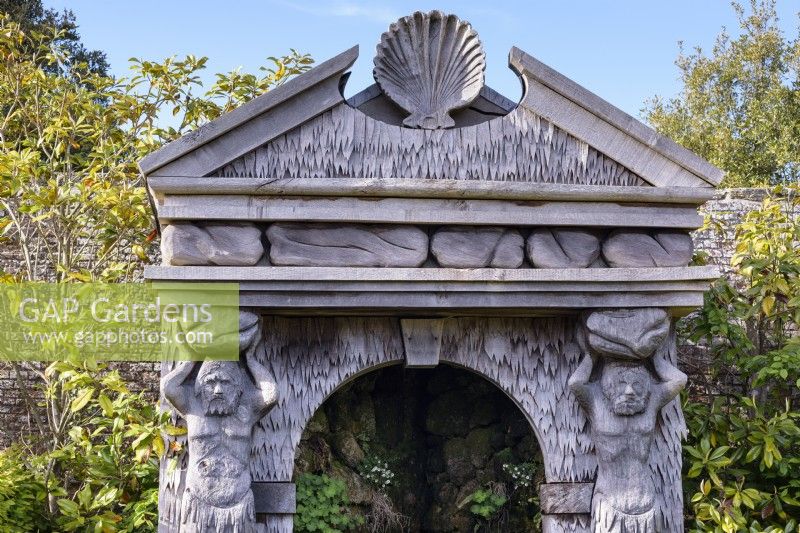 Carved oak temple facade with shell pediment and caryatids that flank the source of an allegorical river in the Collector Earl's Garden at Arundel Castle, West Sussex in May