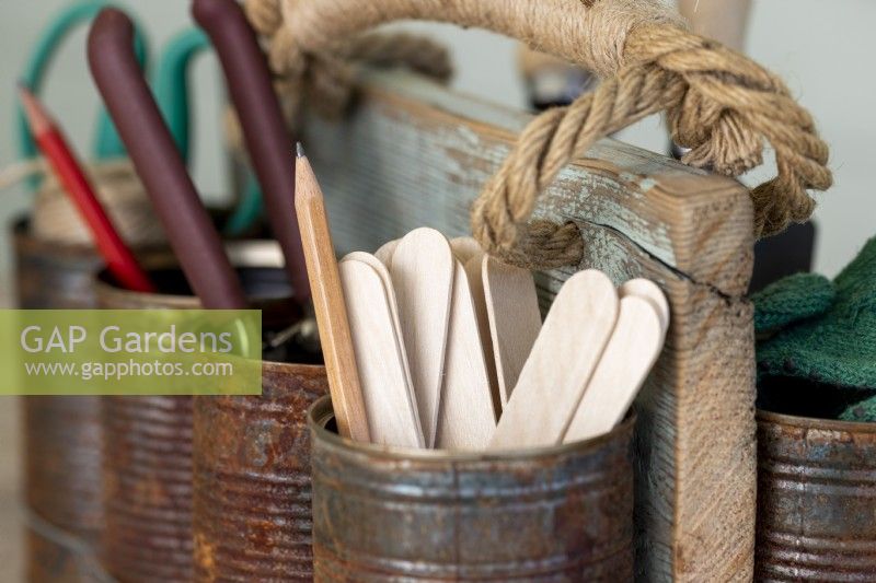 Pencil and wooden plant labels in the tin can caddy