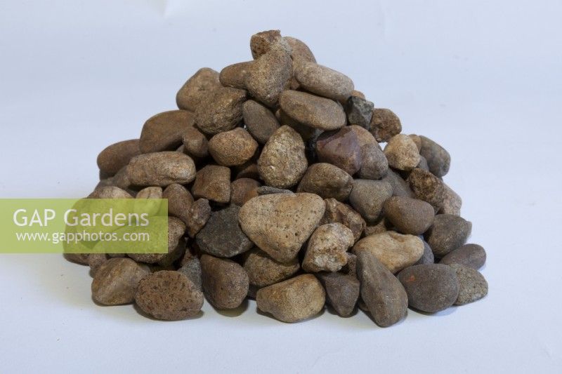 A pile of pebble mulch showing different size or pebbles in the mulch on a white background