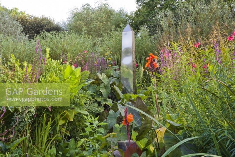 Bog garden with obelisk. Mixed planting with Althea officinalis, Osmunda regalis, Canna x ehemanii, Gunnera manicara and Lythrum salicaria. Designer: Christina Shand