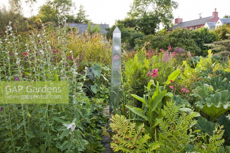 Bog garden with obelisk. Mixed planting with Althea officinalis, Osmunda regalis, Canna x ehemanii, Gunnera manicara and Lythrum salicaria. Designer: Christina Shand