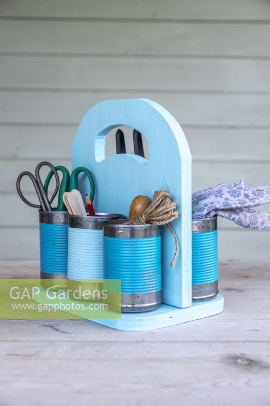 Finished pastel tin can caddy containing gardening tools and supplies