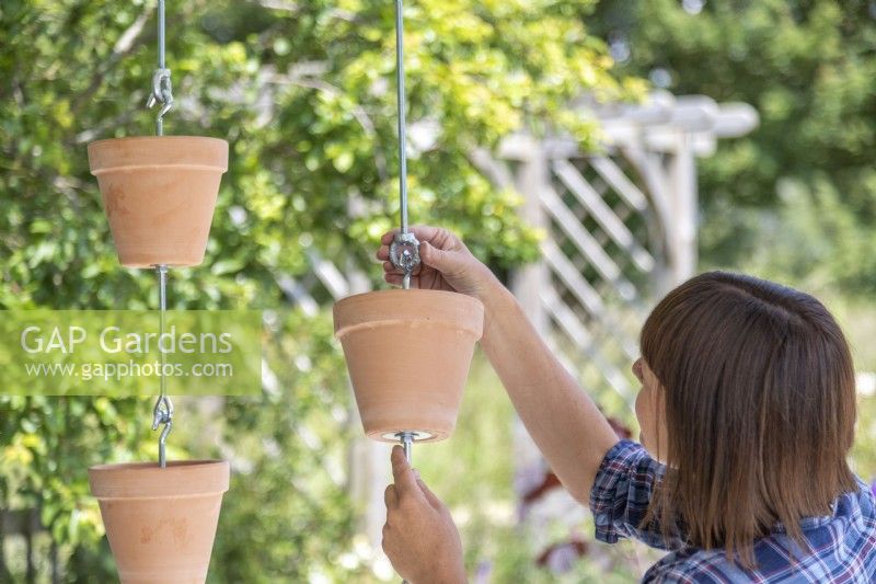 Woman hanging pots onto the tensioners