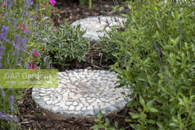 Mosaic stepping stones placed among plants