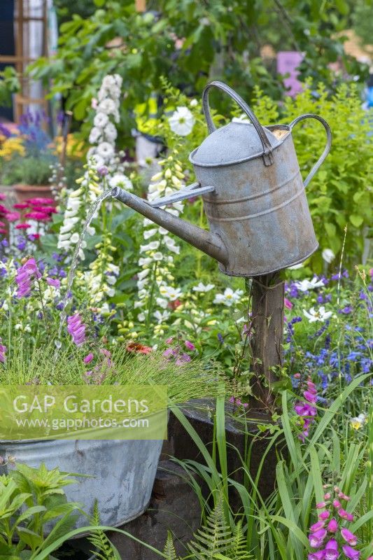Down Memory Lane. A galvanised watering can perched on a post creates an unusual water feature