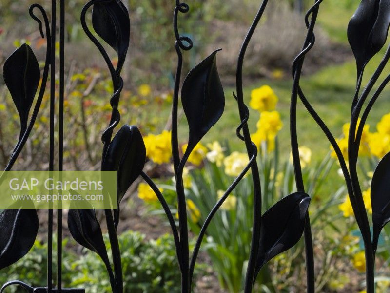 Decorative wrought iron gate view through to flowers  April