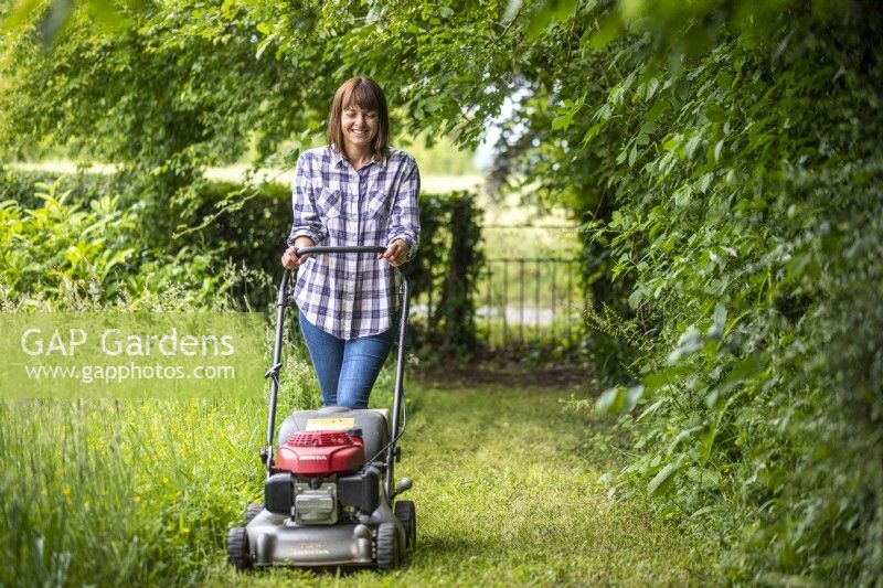 Woman mowing a grass path