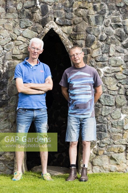 Two men standing by entrance to stone Grotto 