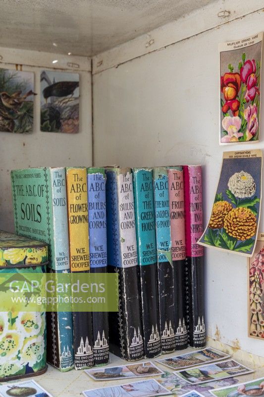 Bookcase with vintage gardening books and postcard
