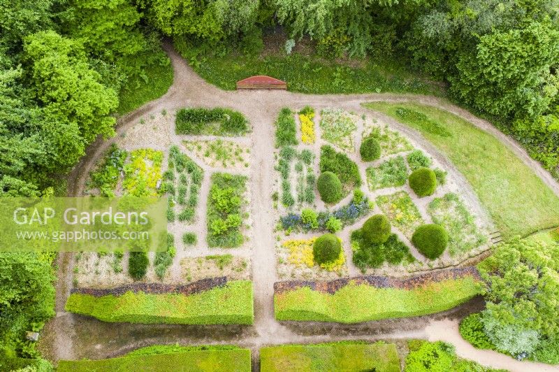 View taken from drone of Grasses Parterre with double hedge of Fagus sylvatica. Block planting of different grasses with gravel paths. July. Summer