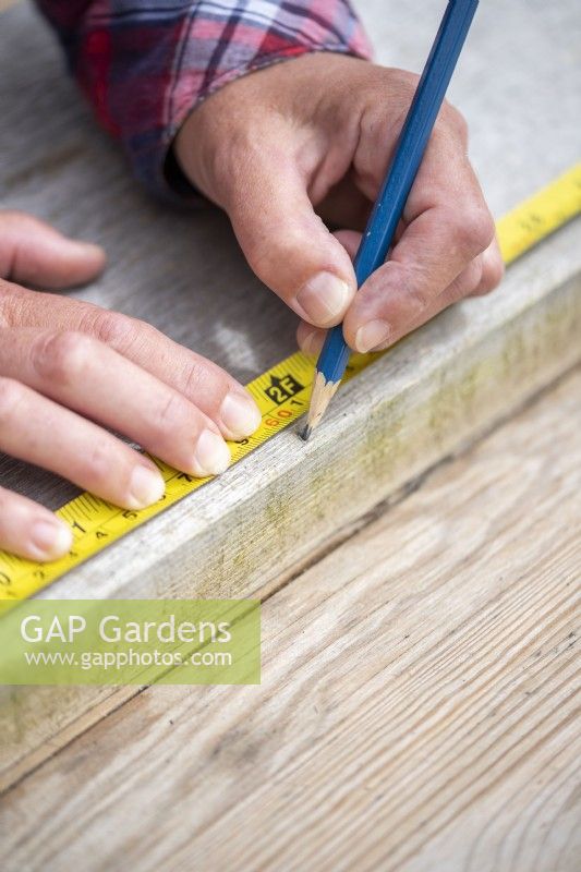 Marking on the wooden board with a pencil at 60cm, 75cm, 95cm and 115cm to get 5 pieces of wood cut to the correct shape