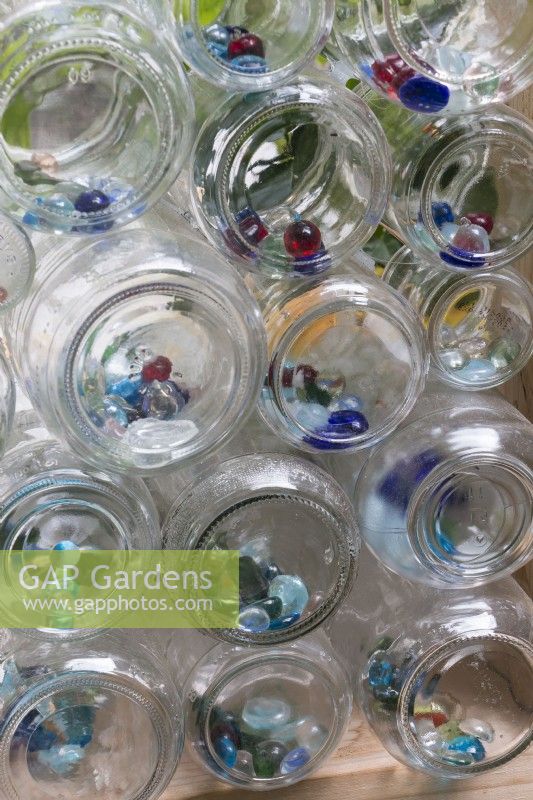 Close up of glass bottles used in recycled greenhouse walls showing colored glass marbles