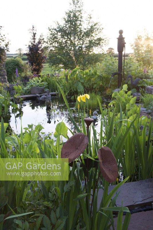 Garden pond with marginal plants and ornaments