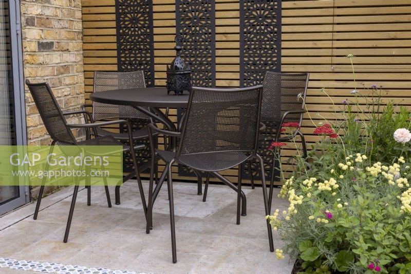 Table and chairs on patio in small suburban garden