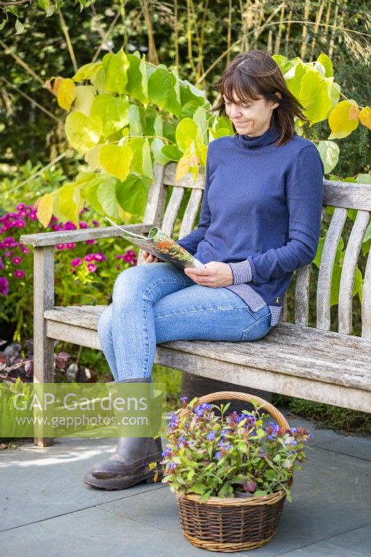 Woman sitting on a bench reading a magazine