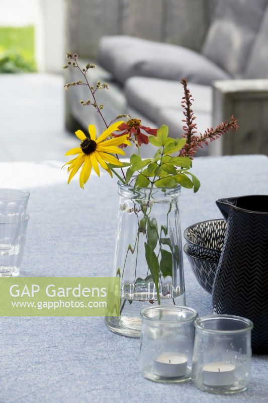 Vase of garden flowers on table.