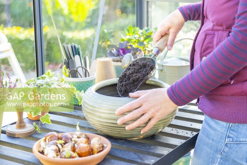 Woman filling the plant pot with compost