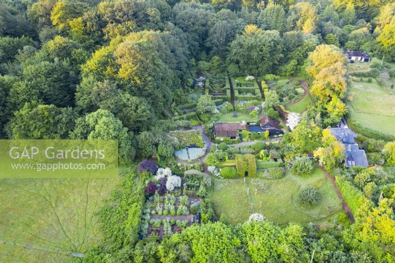 View over whole garden and surrounding properties and woodland; image taken with drone. July. Summer.