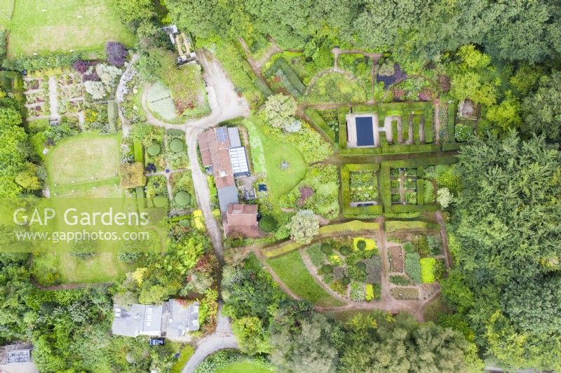 View over whole garden and surrounding woodland with house in centre of image; image taken with drone. September. Summer.