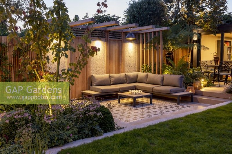 Modern garden patio and pergola at night with lighting