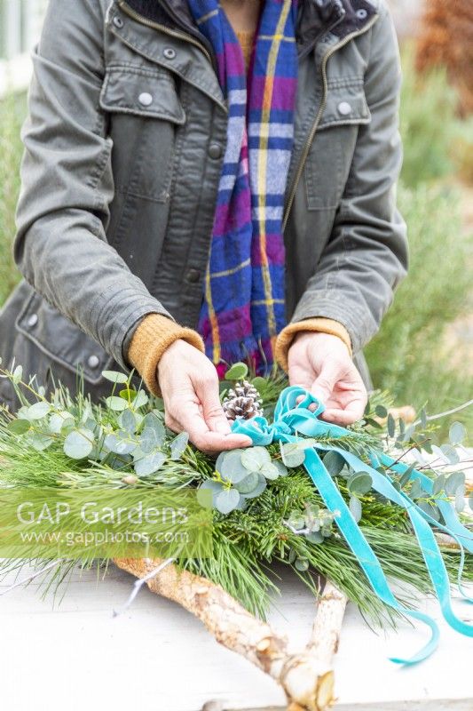 Woman tying a blue ribbon bow onto the star